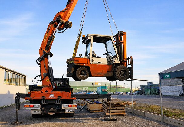 Pickup crane lifting forklift